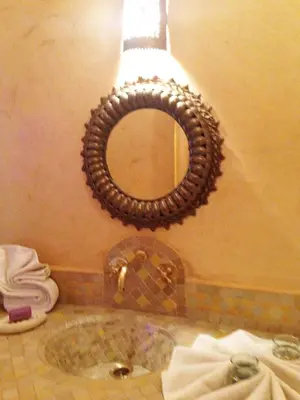 a bathroom with a mirror and a sink at Riad Mehdia & spa in Marrakech