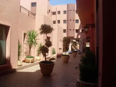 a courtyard with potted plants inront of a building at LINA APPARTEMENT in Marrakech