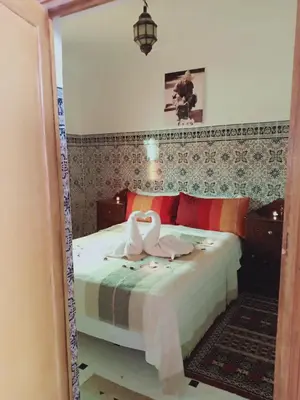 two swans are sitting on a bed in a bedroom at Dar HAJAR in Marrakech