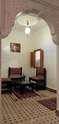 a room with two benches and a table and a mirror at Dar HAJAR in Marrakech
