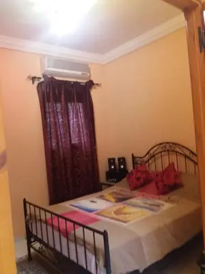 a bedroom with a bed with a red curtain at Riad Safae in Marrakech