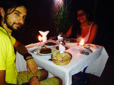 a man and a woman sitting at a table with food at Riad Jakoura in Marrakech