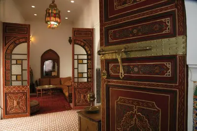 a room with a large wooden door with a mirror at Riad Ifoulki in Marrakech