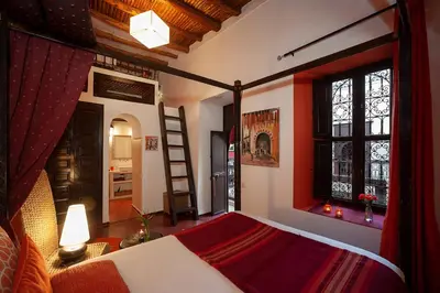 a bedroom with a bed and a ladder in a room at Riad Boussa in Marrakech