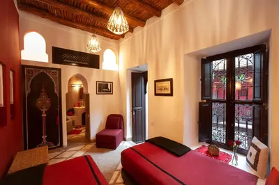 a bedroom with a red bed and a window at Riad Boussa in Marrakech
