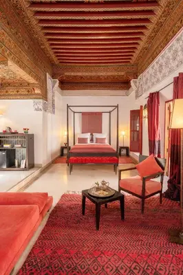 a large bedroom with a bed and a red rug at Riad Dar Karma in Marrakech