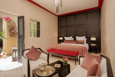 a bedroom with a bed and a couch and a table at Riad Dar Karma in Marrakech