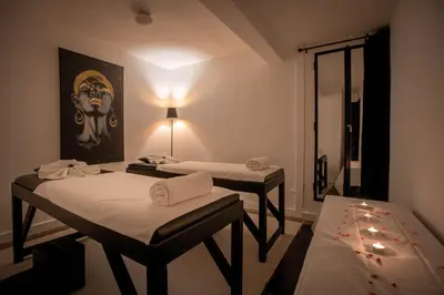 two beds in a room with a painting on the wall at Riad & Spa Azzouz in Marrakech