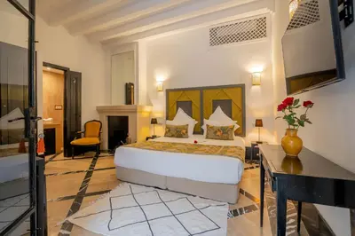 a bedroom with a bed and a desk in a room at Riad & Spa Azzouz in Marrakech
