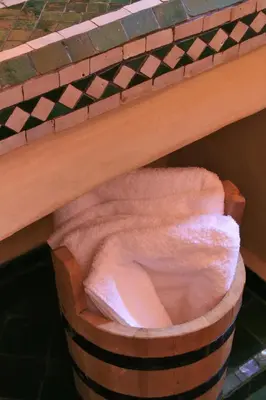 a hamper with a pink towel in it under a table at Riad Honey in Marrakech