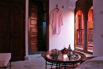 a room with a table and a coat hanging on a wall at Riad Honey in Marrakech