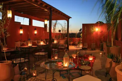 a patio with tables and chairs with lights on it at Riad Honey in Marrakech