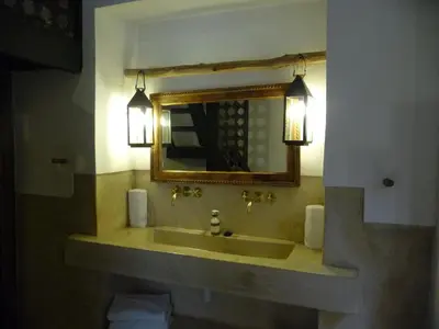 a bathroom with a sink with a mirror and lights at Riad Matham in Marrakech