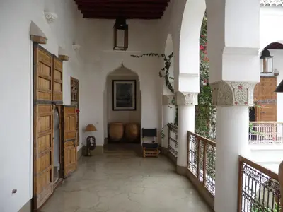 a hallway of a house with an archway and wooden doors at Riad Matham in Marrakech