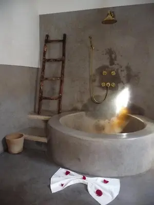 a bath tub with a towel on the floor in a bathroom at Riad Matham in Marrakech