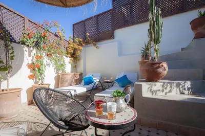 a patio with a table and chairs and potted plants at Dar Halima in Marrakech