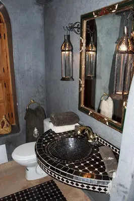 a bathroom with a sink and a toilet and a mirror at Riad Granvilier in Marrakech