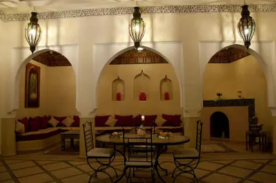 a room with a table and chairs and a couch at Riad Granvilier in Marrakech