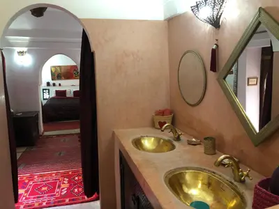 a bathroom with a gold sink and a mirror at Riad Alamine in Marrakech