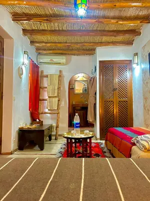a bedroom with a bed and a table in a room at Riad Alamine in Marrakech