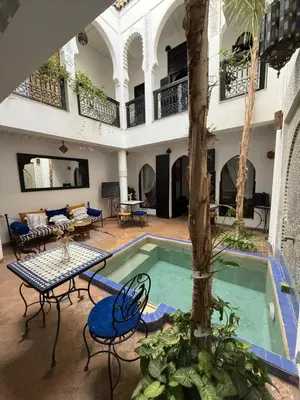 an indoor pool with a table and chairs next to a building at Dar Fangui in Marrakech