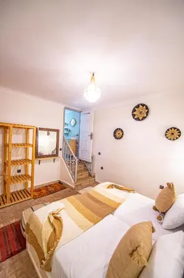 a bedroom with two beds and a staircase at KOUTOBIA ROYAL in Marrakech