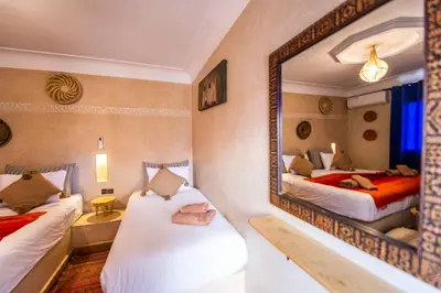 a room with two beds and a mirror at KOUTOBIA ROYAL in Marrakech