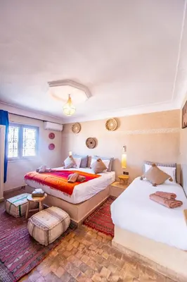 a bedroom with two beds and a couch at KOUTOBIA ROYAL in Marrakech