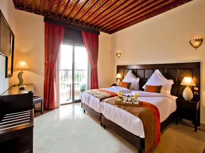 a bedroom with a large bed and a large window at Hotel Lawrence d'Arabie in Marrakech