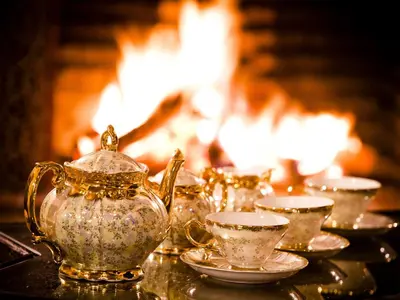 a group of tea pots and cups on a table with a fireplace at Hotel Lawrence d'Arabie in Marrakech