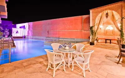 a stage with a table and chairs on a stage at Hotel Lawrence d'Arabie in Marrakech