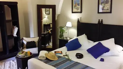 a bedroom with a bed with blue and white pillows at Riad Al Ksar & Spa in Marrakech