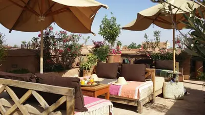 a patio with umbrellas and a table and chairs at Riad Al Ksar & Spa in Marrakech