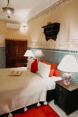 a bedroom with a bed and two lamps on a table at Riad Hotel Sherazade in Marrakech