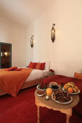 a bedroom with a bed and a table with food on it at Riad Dar Aicha en Exclusivité in Marrakech