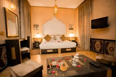 a hotel room with a bed and a table at Palais Dar Si Aissa ALL-SUITES in Marrakech