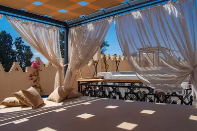 a bedroom with a bed with white drapes at Palais Dar Si Aissa ALL-SUITES in Marrakech