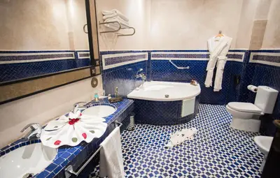 a bathroom with a sink and a tub and a toilet at Palais Dar Si Aissa ALL-SUITES in Marrakech