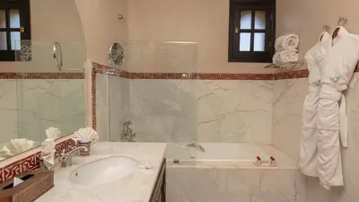 a bathroom with a tub and a sink and a bath tub at L'OLIVERAIE DE L'ATLAS in Marrakech