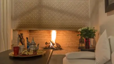 a fireplace with a plate of food on a table at Dar Akal in Marrakech