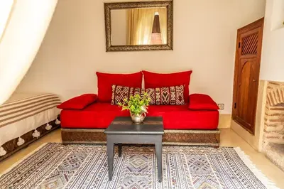 a red couch in a living room with a table at Riad Smara in Marrakech