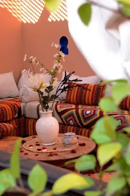 a living room with a vase with flowers on a table at Dar LEULEU in Marrakech