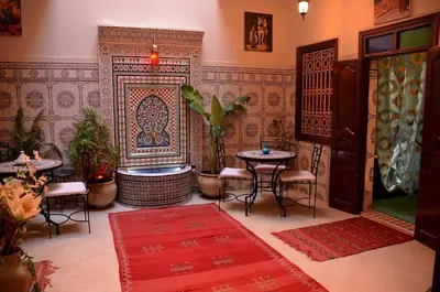 a room with a table and chairs and a tub at Dar LEULEU in Marrakech