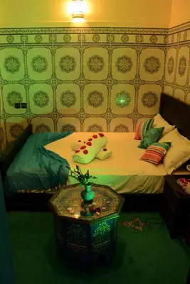a bedroom with a bed and a table with a table sidx sidx sidx at Dar LEULEU in Marrakech