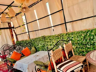 a room with a table and chairs and a green wall at Riad Lalla Marrakech in Marrakech