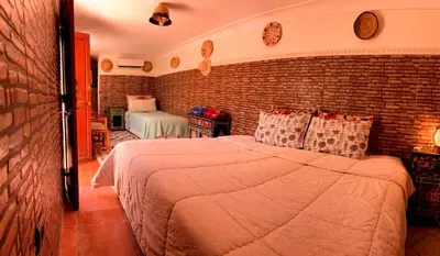 a bedroom with a large bed and a brick wall at Riad Lalla Marrakech in Marrakech