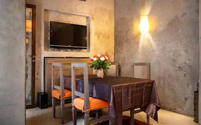 a dining room with a table and a tv at Riad Vanilla Sma & Spa in Marrakech