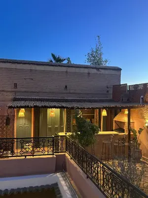 a building with a balcony with a table and chairs at Riad Ecila in Marrakech