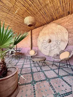 a room with chairs and tables and a ceiling at Riad Ecila in Marrakech