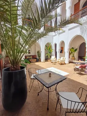 a courtyard with a table and a potted plant at Riad Miski in Marrakech
